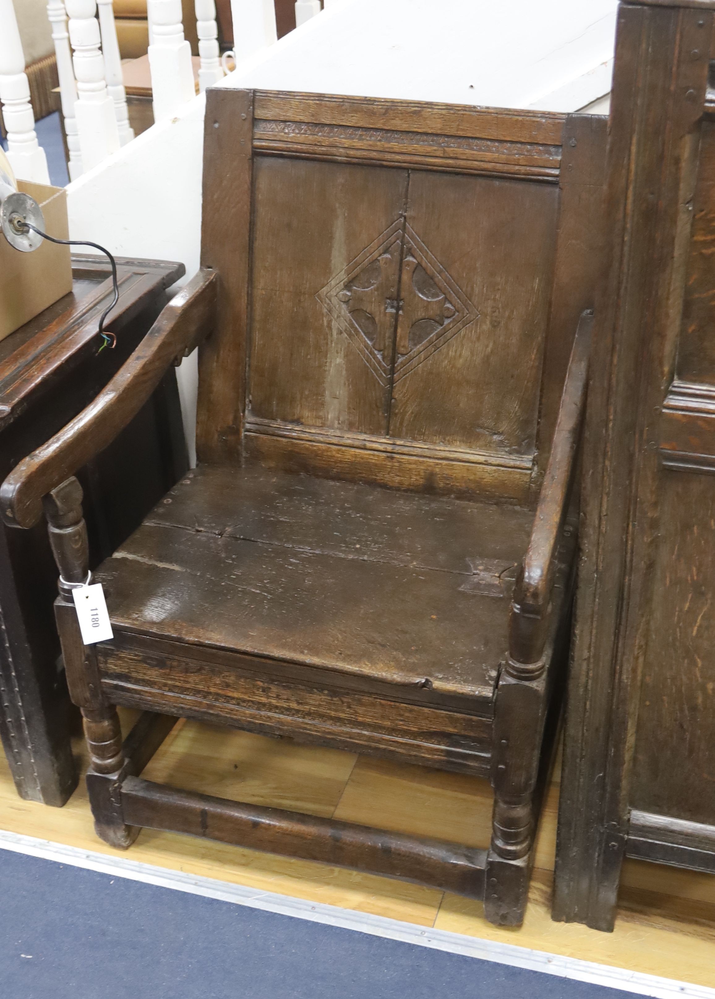 A joined oak merchant’s wainscot box-seated chair, the twin panelled back carved with a stylised cross in diamond device, early-mid 17th century, width 62cm, depth 62cm, height 91cm